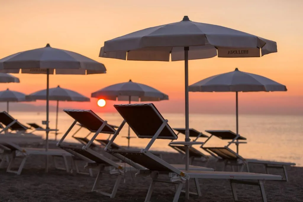 Ombrelloni e sdraio sulla spiaggia al tramonto