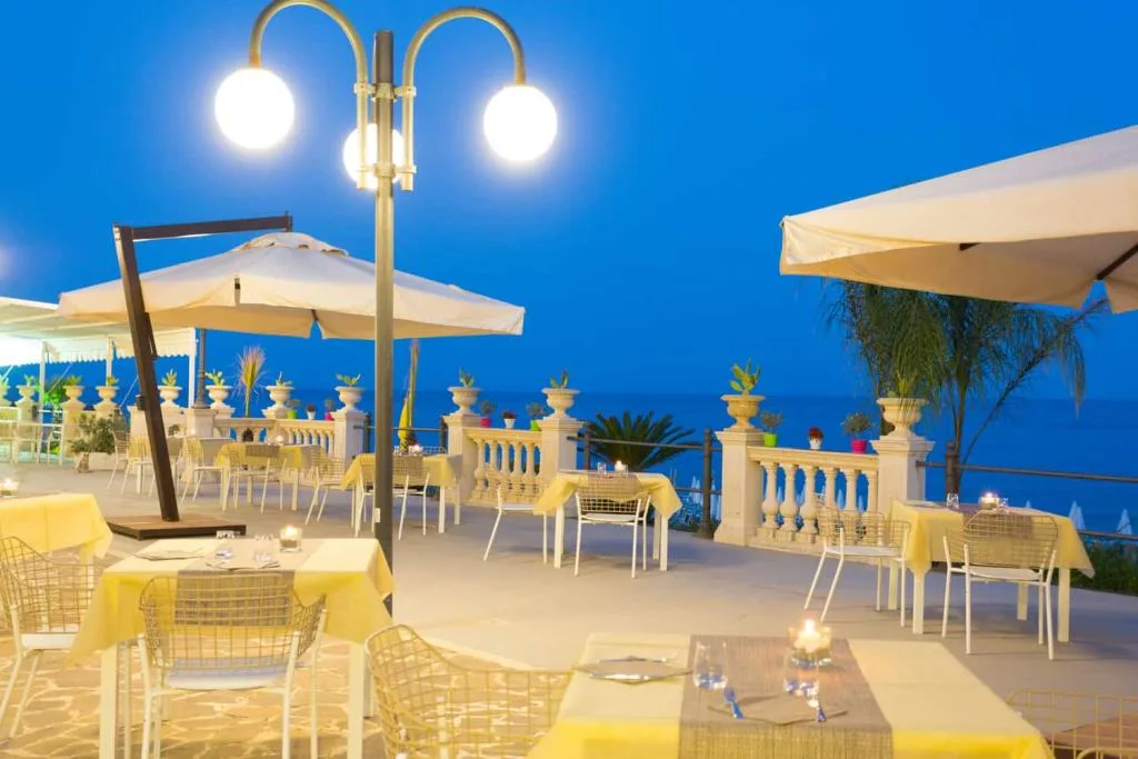 Ristorante all'aperto illuminato di sera vista mare
