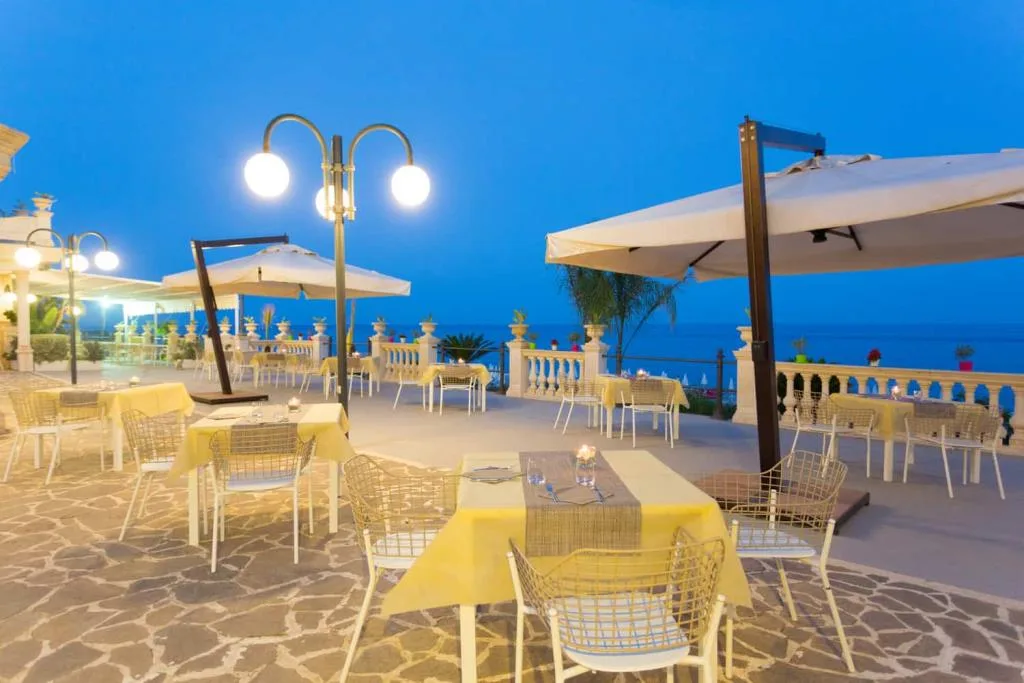 Tavoli apparecchiati sulla terrazza di sera con luci