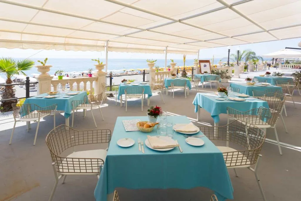 Terrazza ristorante con tovaglie azzurre vista mare