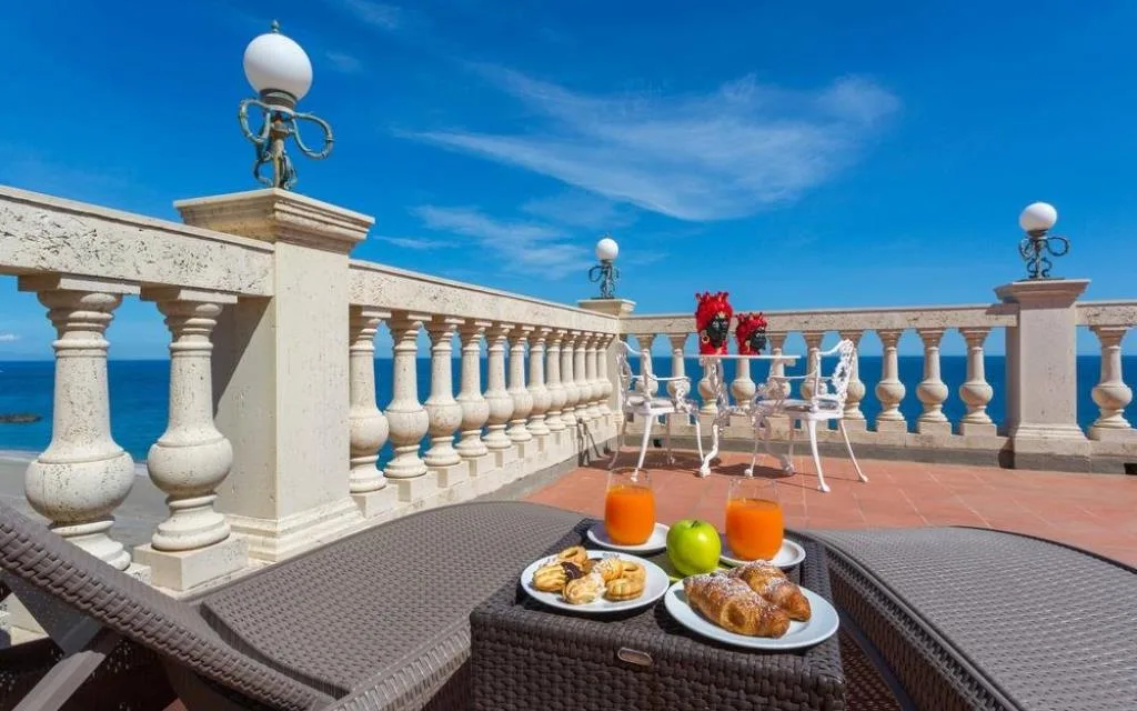 Terrazza con colazione servita e balaustra vista mare