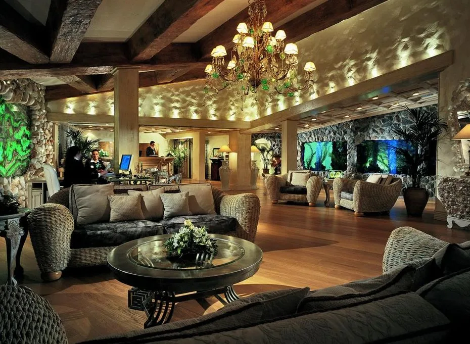 Lobby raffinata con divani in vimini, lampadario e pareti in pietra illuminate
