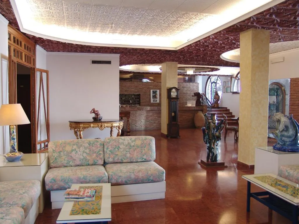 Hall dell'hotel con divano floreale, tavolo dorato e reception in mattoni