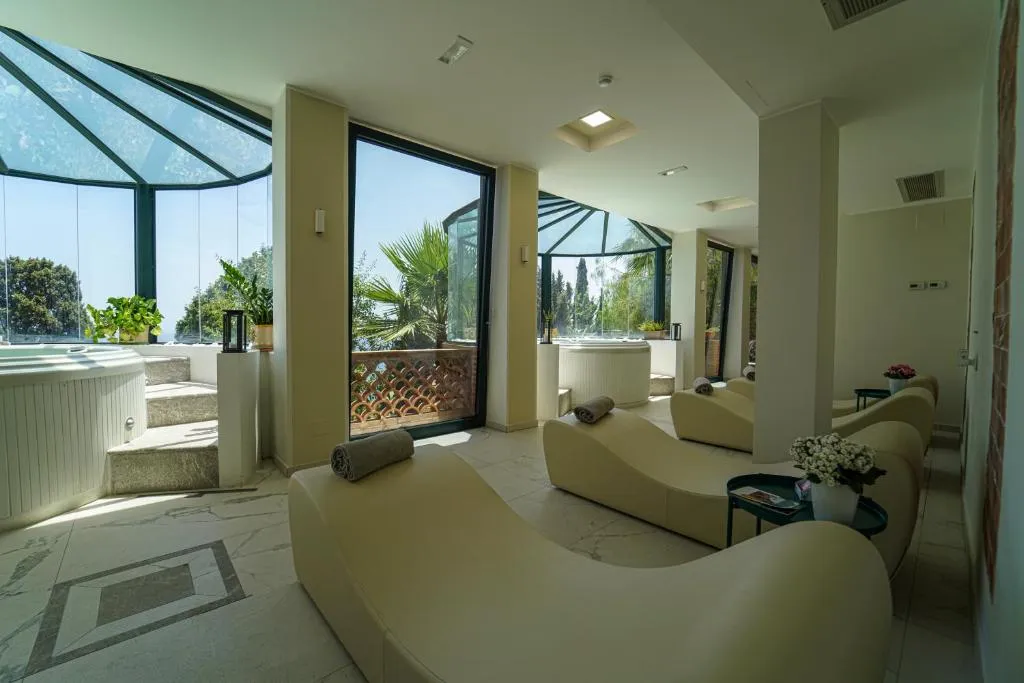 Area relax della spa con lettini ergonomici, vasche idromassaggio e ampie vetrate