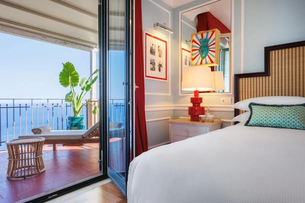 Camera con letto matrimoniale e balcone affacciato sul mare al tramonto